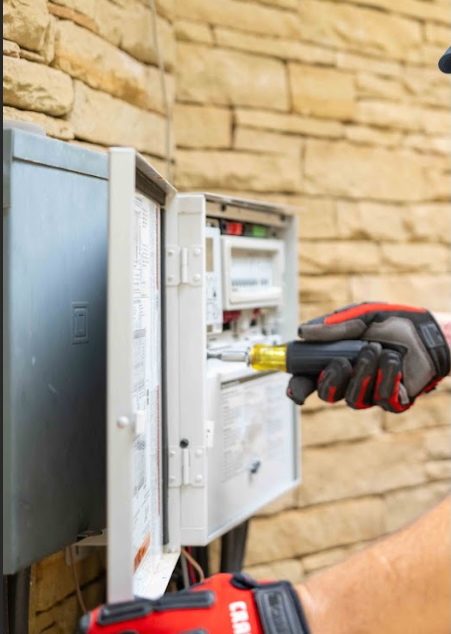 Technician servicing a pool equipment panel